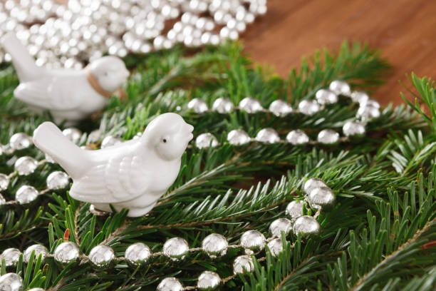 istock Closeup of pine tree branches decorated with beads garland 871962890