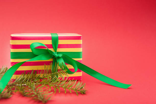 istock Christmas holiday wrapped gift box on light red background 871966352