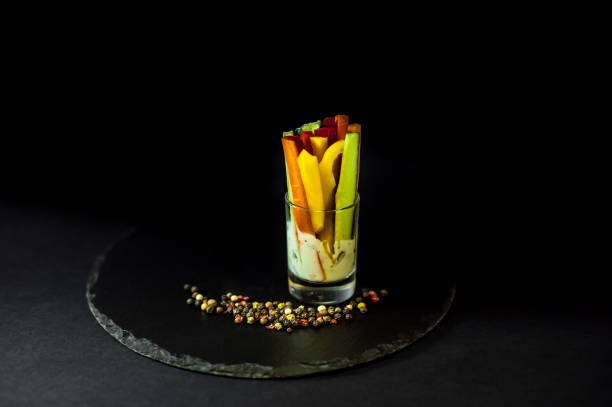 istock snack in a glass cup on a black slate. Peppers with sauce 871967074