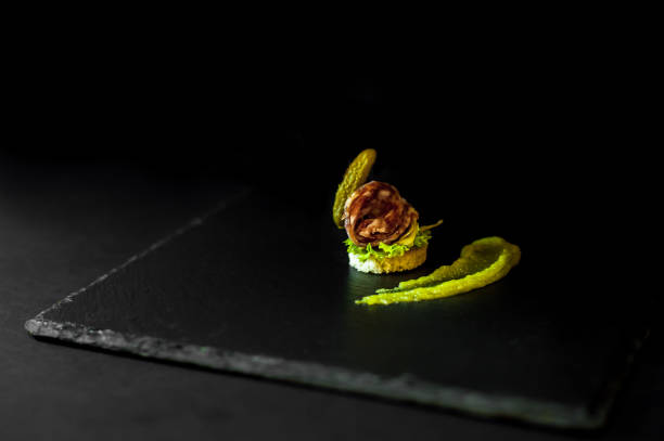 istock canap s with marinated cucumber, mustard and salami. black background and slate. 871967292