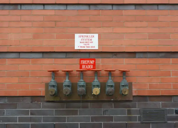 Six firepump test headers on red brick wall, for testing the flow capacity of fire pumps