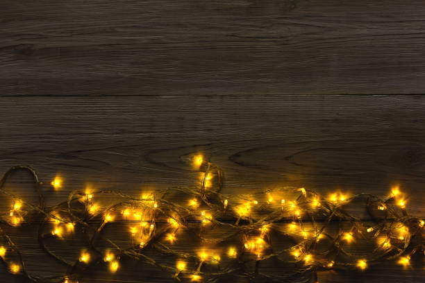 istock Christmas lights border on grey wooden background 871976360