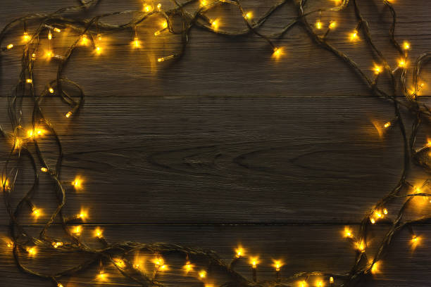 istock Christmas lights frame on grey wooden background 871976428