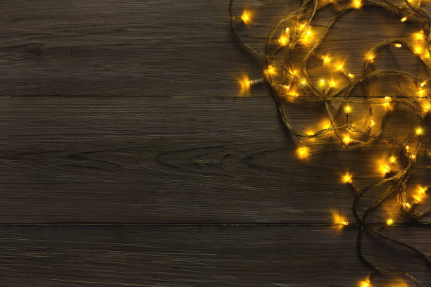 istock Christmas lights border on grey wooden background 871976480