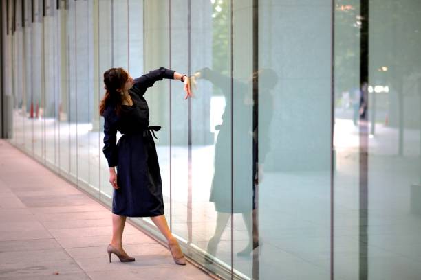 istock Young woman performing dancing pose at mirror of building 871976748