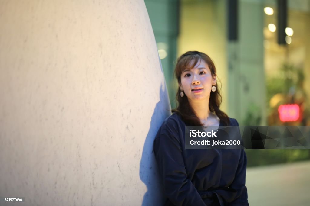 Young woman relaxing at stone objet @ Marunouchi shopping area 20-29 Years Stock Photo