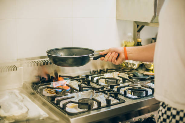 istock Chef cook prepares meal on frying pan in the kitchen 871980532