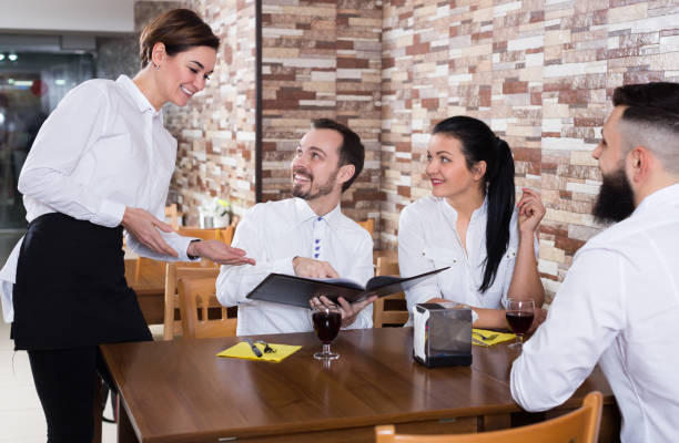 istock Charming young waiter receiving order from guests 871980922