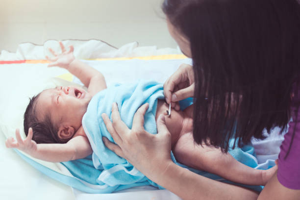 matka czyszcząc pępek azjatyckiej noworodka dziewczynka wacikiem zwilżonym alkoholem po kąpieli - belly button zdjęcia i obrazy z banku zdjęć