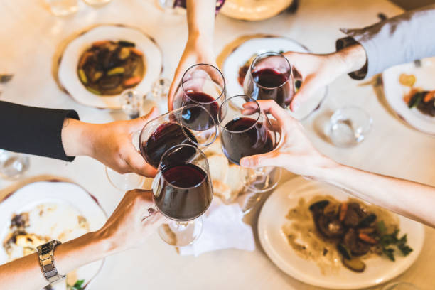 istock People toasting with red wine at restaurant 871986608