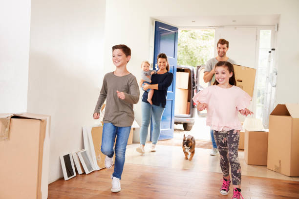 familia llevando cajas en nuevo hogar en movimiento día - 6 11 meses fotografías e imágenes de stock