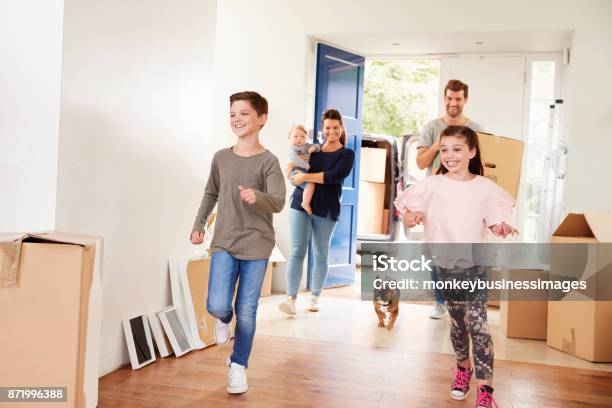 Family Carrying Boxes Into New Home On Moving Day Stock Photo - Download Image Now - Family, Moving House, Relocation