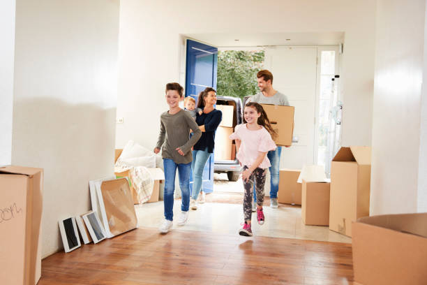 istock Family Carrying Boxes Into New Home On Moving Day 871996422