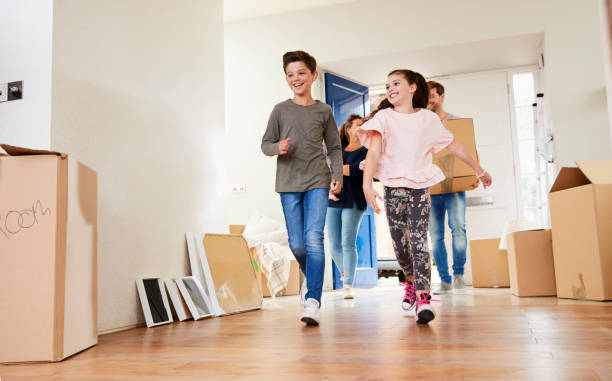 istock Family Carrying Boxes Into New Home On Moving Day 871996428