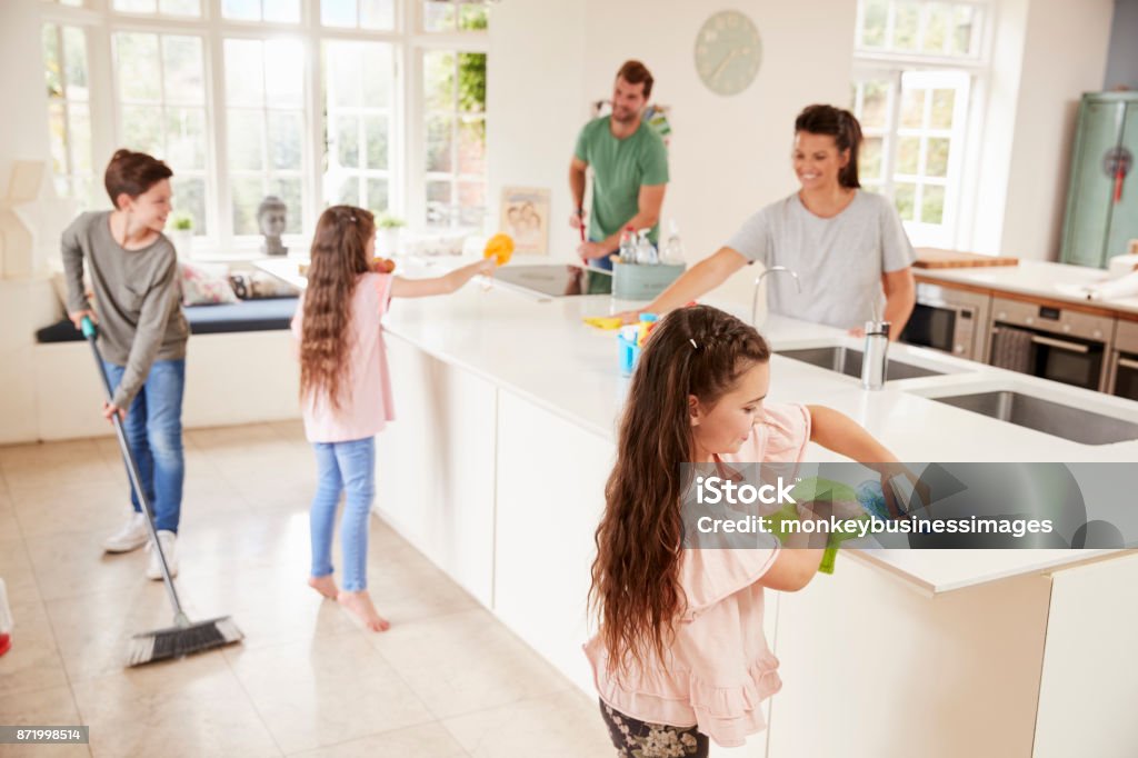 Children Helping Parents With Household Chores In Kitchen Cleaning Stock Photo