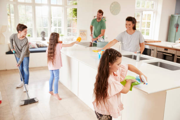 Children Helping Parents With Household Chores In Kitchen Children Helping Parents With Household Chores In Kitchen chores stock pictures, royalty-free photos & images