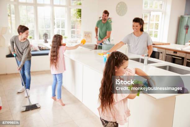 Children Helping Parents With Household Chores In Kitchen Stock Photo - Download Image Now