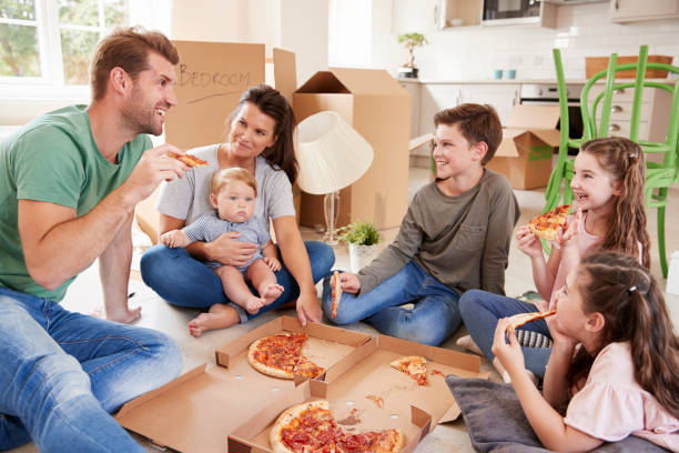 istock Family Celebrating Moving Into New Home With Pizza 872001148