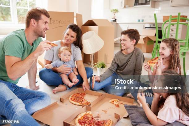 Family Celebrating Moving Into New Home With Pizza Stock Photo - Download Image Now - 10-11 Years, 30-39 Years, 6-11 Months