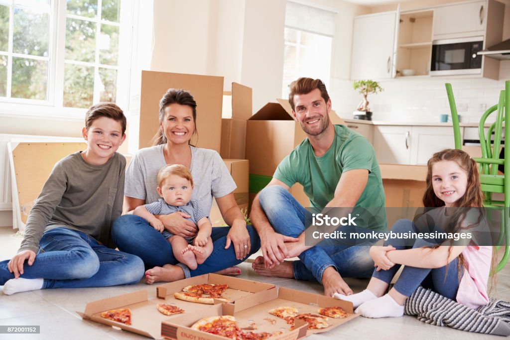 Portrait Of Family Celebrating Moving Into New Home With Pizza 10-11 Years Stock Photo