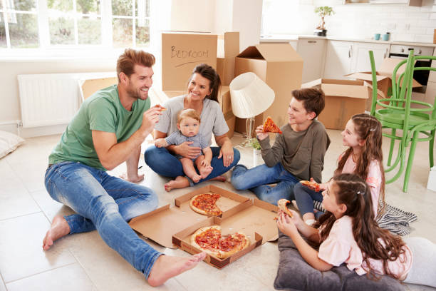 istock Family Celebrating Moving Into New Home With Pizza 872001154