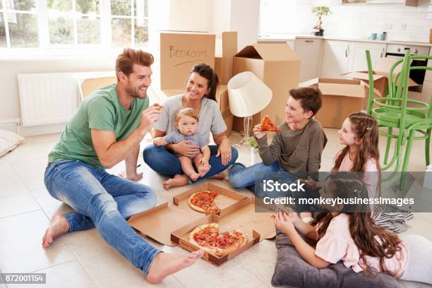 Family Celebrating Moving Into New Home With Pizza Stock Photo - Download Image Now - Eating, Family, Flooring