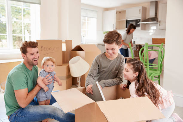 istock Children Helping Parents To Unpack On Moving In Day 872001156