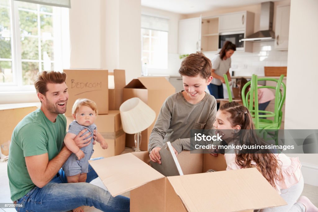 Children Helping Parents To Unpack On Moving In Day 10-11 Years Stock Photo