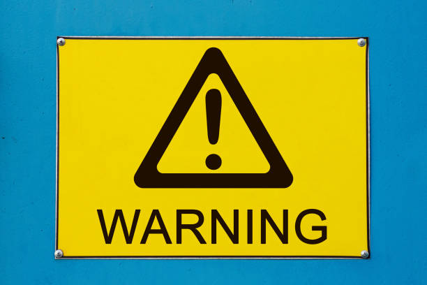 Warning sign on yellow metallic board stock photo