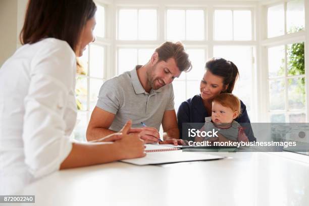 Family With Baby Meeting Financial Advisor At Home Stock Photo - Download Image Now - Family, Signing, Insurance