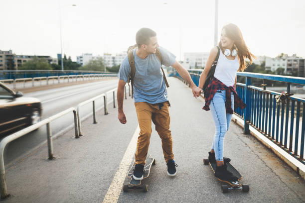 istock Young attractive couple riding skateboards and having fun 872005430