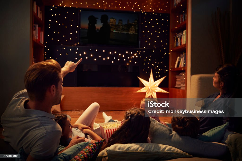 Family Enjoying Movie Night At Home Together Family Stock Photo