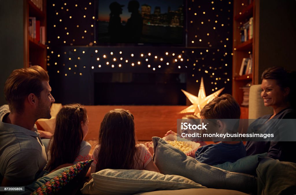 Family Enjoying Movie Night At Home Together Family Stock Photo