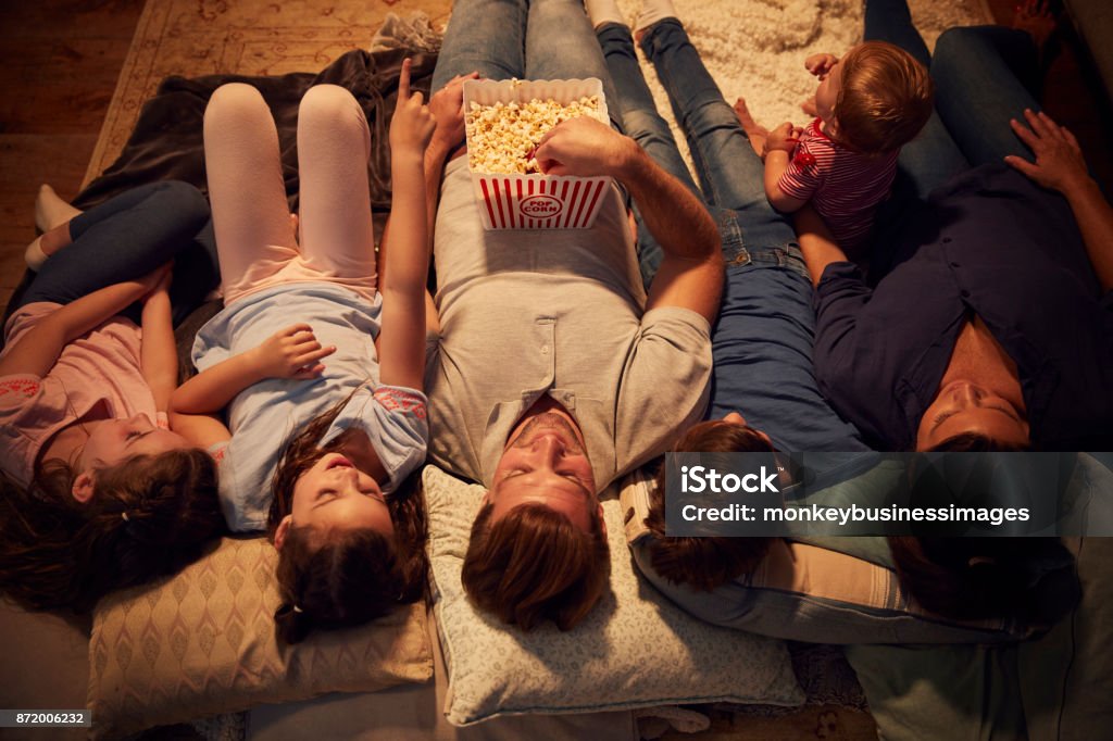 Overhead View Of Family Enjoying Movie Night At Home Together Family Stock Photo