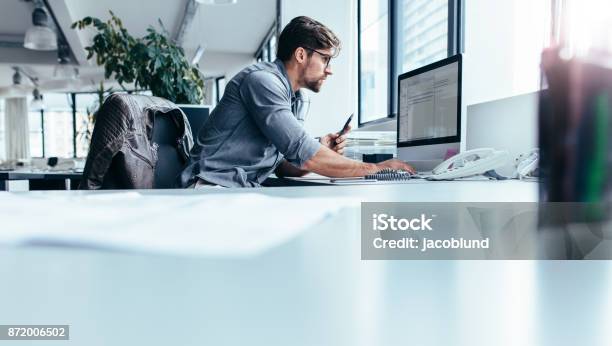 Young Businessman In Office Working On Computer Stock Photo - Download Image Now - Office, Working, Computer Monitor