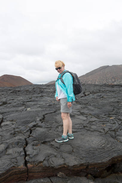 istock Middle aged woman exploring a lava field on Bartolome island (Galapagos) 872007004