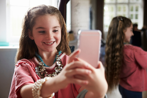 Girl Playing Dressing Up Game Taking Selfie On Mobile Phone