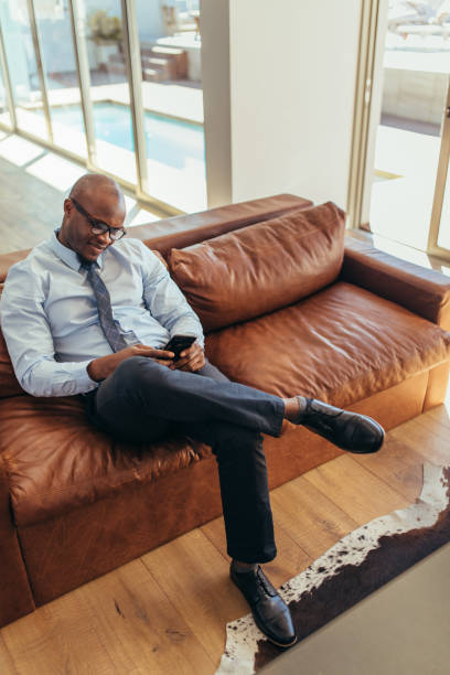 istock Businessman sitting on lounge using mobile phone 872010424
