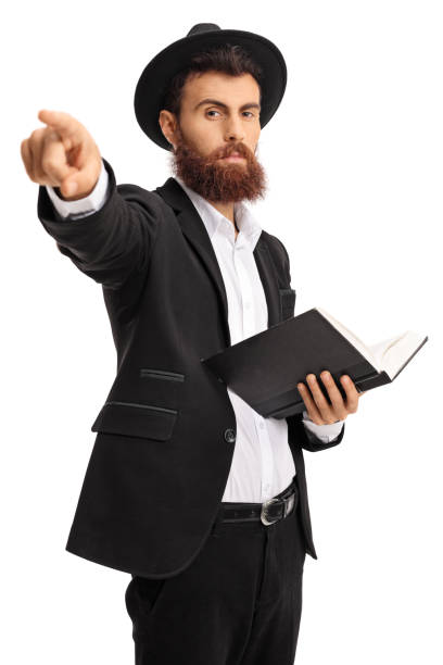 istock Religious man with a book pointing at the camera 872017410