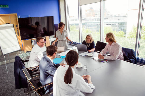 istock Businesswoman Around a Table with Work Colleagues 872019110