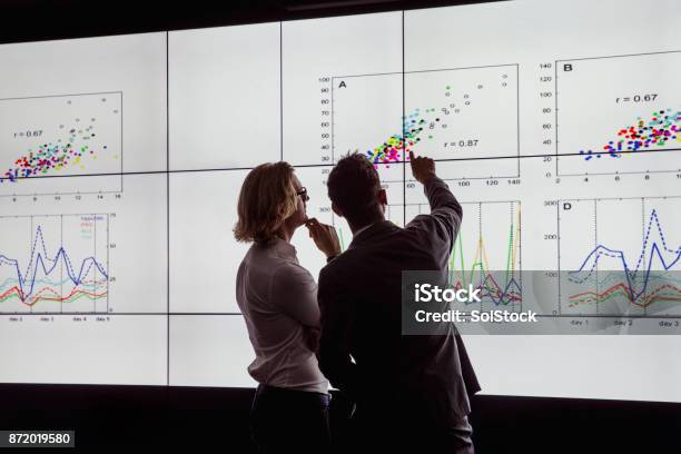 Men Viewing A Large Screen Of Information Stock Photo - Download Image Now - Data, Analyzing, Research