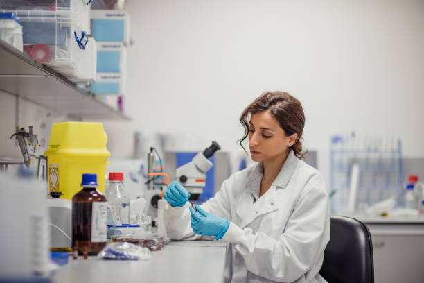 Disease Diagnosis Laboratory Patient personal health care taken by a specialist biochemist in a London research facility. One women in the lab cancer screening stock pictures, royalty-free photos & images