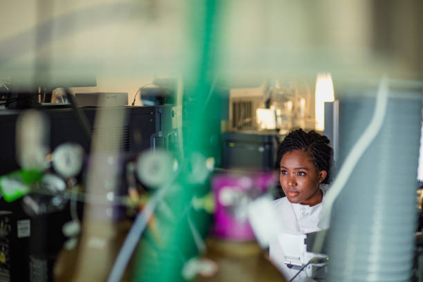 Female in a Medical Science Research Facility Patient personal health care taken by a specialist biochemist in a London research facility. Woman sat down surrounded by computers and machinery biochemist stock pictures, royalty-free photos & images