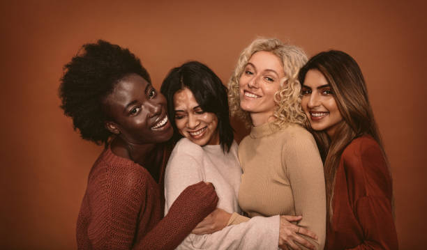 group of cheerful young women standing together - multiracial woman imagens e fotografias de stock