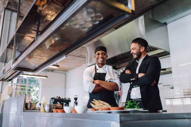 istock Smiling restaurant owner and chef standing in kitchen 872038142