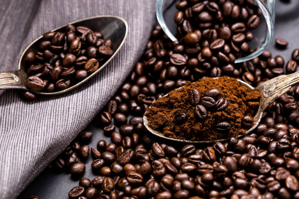 istock Coffee poured into an ancient antique silverware spoon. Around the spoons scattered coffee beans. 872049008