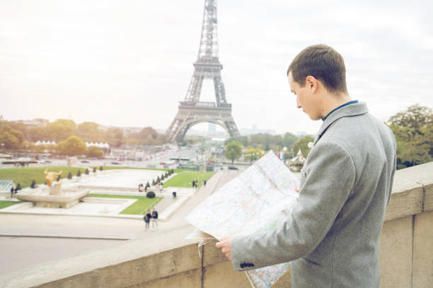 istock Businessman visiting Paris, holding street map - Eiffel Tower 872052072