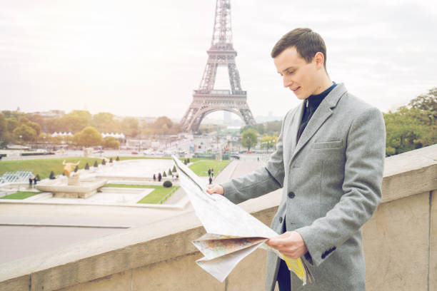 istock Male in Paris looking at map, Eiffel Tower- France 872053174
