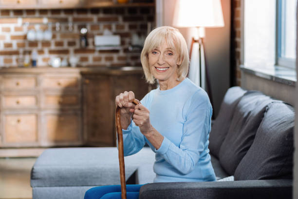 istock Cheerful pensioner sitting with a walking stick and smiling 872062310