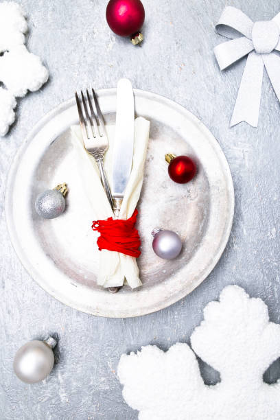 istock Christmas table place setting. Holidays background. Silver plate, knife and fork with christmas decorations. Top view. 872071346